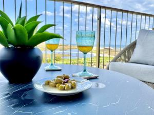 a table with a plate of food and two wine glasses at Bayline - 2 room Spa-Pool & Gym in Armação de Pêra