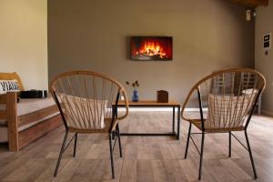 two chairs and a table in a room with a fireplace at La Josefina Casa Quinta. in Azul +28 photos