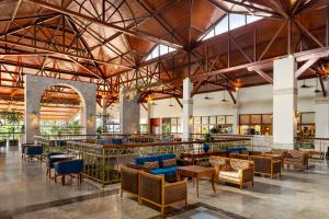 a lobby of a hotel with tables and chairs at Grand Palladium Imbassaí Resort & Spa - All Inclusive in Imbassai
