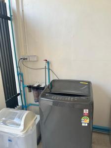 a small refrigerator in a room with a trash can at Cozy townhome in Krabi town in Ban Khlong Chi Lat