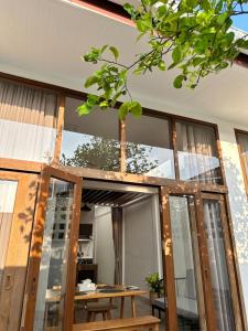 a house with glass doors and a wooden table at Cozy townhome in Krabi town in Ban Khlong Chi Lat