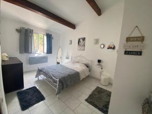 a bedroom with a bed and two rugs at Maison T3 in Piana