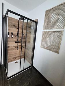 a shower in a room with a wooden wall at Ferienhaus Kronweiler in Kronweiler +20 photos