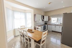 a kitchen with a wooden table and chairs in it at Coffee Cottage Portrush Holiday Home Self Catering in Portrush +22 photos