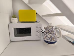 a microwave and a vase sitting on a counter at To Be (2B) in Malaga in Málaga