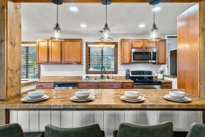 eine Küche mit einer großen Holztheke mit Stühlen in der Unterkunft Cozy Blue Cottage with Hot Tub, 5min to Downtwn Gatlinburg in Gatlinburg