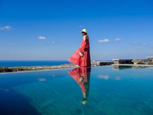 a woman in a red dress standing in the water at Avan Luxury Villas in Pyrgos