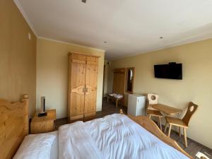 a bedroom with a bed and a desk and a television at Transylvanian Views in Peştera