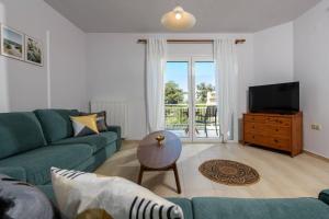 a living room with a blue couch and a television at Agapi Deluxe Villa in Skala Rachoniou