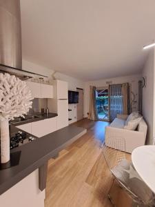 a kitchen and living room with a couch and a table at Cozy Apartment - Iseo Lake in Paratico