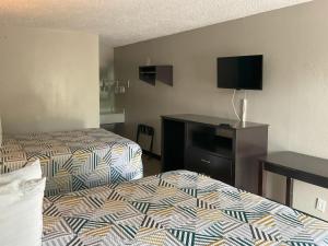 a hotel room with two beds and a flat screen tv at Motel 6 Baton Rouge East, LA I12 in Baton Rouge