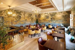 a restaurant with tables and chairs and a wall mural at The Kings Arms in Christchurch