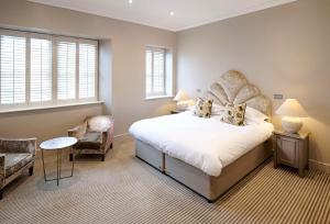 a bedroom with a large bed and a chair at The Kings Arms in Christchurch