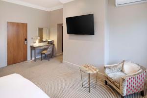 a hotel room with a bed and a chair and a desk at The Kings Arms in Christchurch