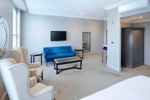 a hotel room with a blue couch and a tv at The Kings Arms in Christchurch