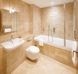 a bathroom with a toilet and a sink and a tub at The Kings Arms in Christchurch