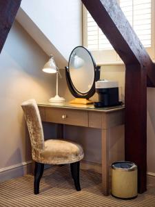 a dressing table with a mirror and a chair at The Kings Arms in Christchurch