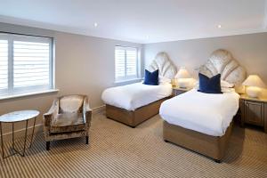 a hotel room with two beds and a chair at The Kings Arms in Christchurch