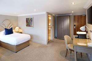 a hotel room with a bed and a desk at The Kings Arms in Christchurch