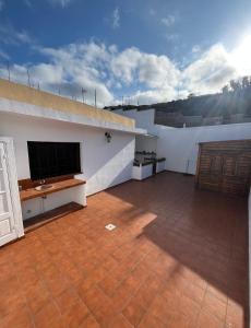 una grande stanza con una TV a schermo piatto in un edificio di Whispering Tides Villa a Candelaria