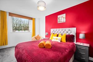 Un dormitorio rojo con una gran cama roja con almohadas amarillas. en Peaceful cosy stay with FREE parking, en Brierley Hill