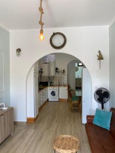 ペニシェにあるNortadas Houseのアーチ道のあるリビングルーム、キッチンが備わります。