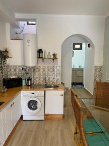 ペニシェにあるNortadas Houseのシンクと洗濯機付きのキッチン +14枚の写真