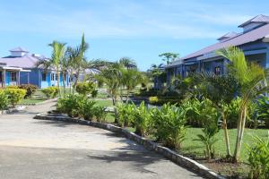 a row of houses with palm trees and a driveway at Funworld Plaza Hotel in Nadi