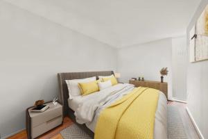 a bedroom with a bed with a yellow blanket at SG, Charming Chelsea Balcony Suite in London
