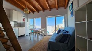 a living room with a couch and a kitchen with a table at Sea View Apartment Carrapateira in Carrapateira
