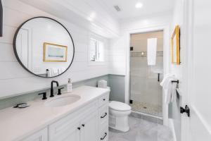 a white bathroom with a sink and a mirror at The Newport Lofts - 543 Thames Street in Newport +23 photos