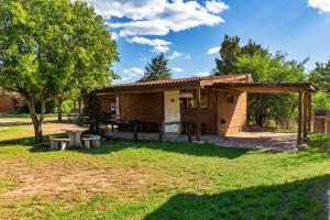 een klein huis met een picknicktafel in een tuin bij Quebrada del Viento - Cabañas in Los Hornillos
