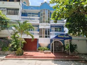 un edificio blu e bianco con un cartello davanti di HOSTAL PARMA a Santa Marta