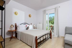a bedroom with a bed and a chair and a window at Agapi Deluxe Villa in Skala Rachoniou