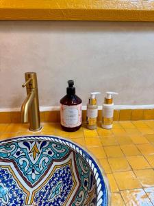 Baño con 3 botellas de jabón y lavamanos en BABSA Home, en Essaouira
