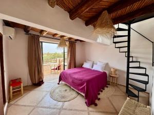 Un dormitorio con una cama con una manta morada. en BABSA Home, en Essaouira