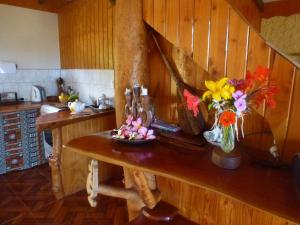 una cocina con una mesa con un jarrón de flores. en Cabaña Oreko, en Hanga Roa