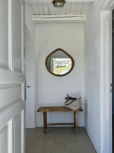 a hallway with a wooden bench and a mirror at Blue and white Mykonos in Mikonos