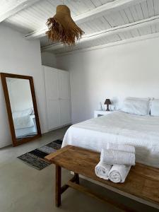 a white bedroom with a bed and a mirror at Blue and white Mykonos in Mikonos