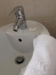 La salle de bains est pourvue d'un lavabo et d'une serviette blanche. dans l'établissement B&B Daniel, à Silea