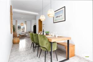 Un comedor con una mesa y sillas verdes. en ViVi Homes - Casa Elola, en Fuengirola