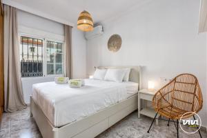 a bedroom with a bed and a chair and a window at ViVi Homes - Casa Elola in Fuengirola