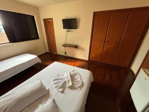 a bedroom with a bed and a dresser with two towels at Hotel Candidez in Piauí