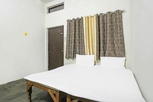 a bedroom with two beds and a window at Hotel O Brothers in Bijnor +21 photos