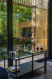 a glass table with a vase of flowers on it at Water Hideout - Floating Luxury in Pure Wilderness in Wysoka
