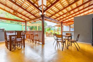 a dining area with tables and chairs and a wooden ceiling at Espaço inteiro:piscina aquecimento solar,2 suítes in Pirenópolis