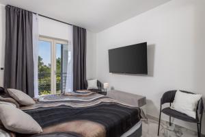 una camera da letto con un letto e una TV a schermo piatto di Vila Lux 2 a Fiume (Rijeka)