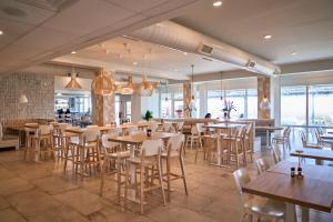 a restaurant with wooden tables and chairs and windows at North Shore Oceanfront Resort Hotel in Myrtle Beach