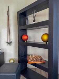 a shelf with a chess board and balls on it at Modernes Bergblick Apartment im Herzen von Andermatt Sonne & Terasse in Andermatt