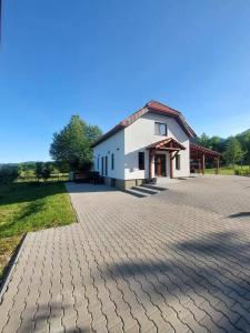 a building with a brick driveway in front of it at Cabana Gap House in Colţeşti